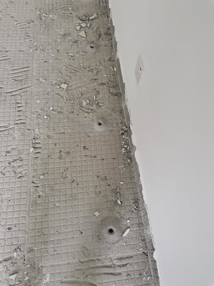 施工中建筑的墙脚边,一排钻好的注药孔。